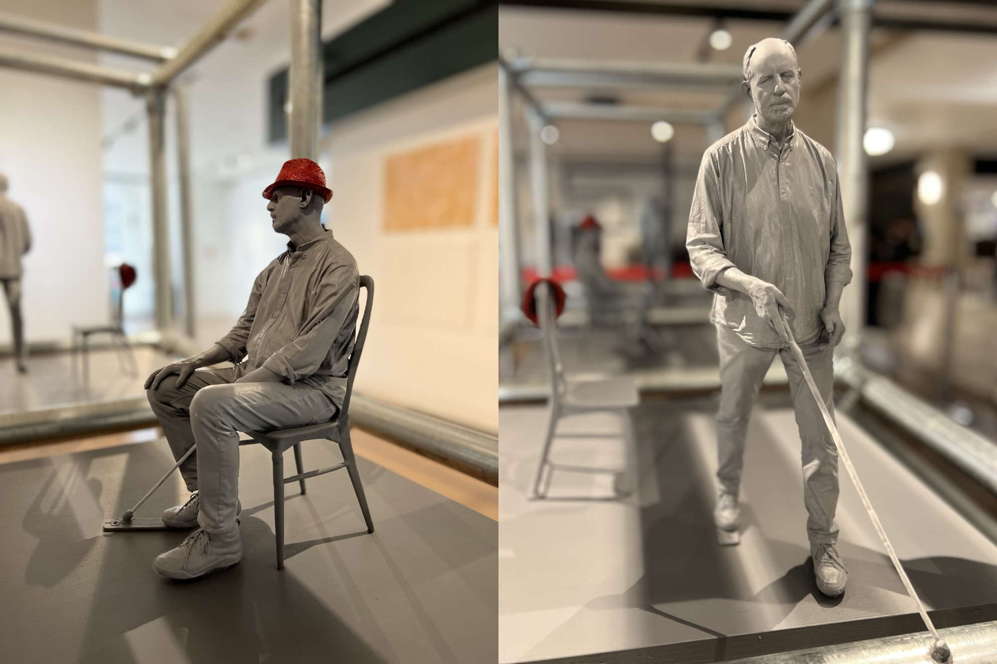 This image shows two perspectives of a 3D sculpture surrounded by a steel frame. The sculpture has three separate sculptures. The rightmost image shows a sculpture of David using his cane as he passes a chair with a red hat positioned on its corner. The leftmost image shows a sculpture of David sitting on a chair with the red hat on his head. The final sculptural scene (not pictured) shows a mirroring of the first sculpture of David using his cane and now passed the chair with the red hat positioned on its corner. In the background of the image are students and persons congregating in the social gallery area.